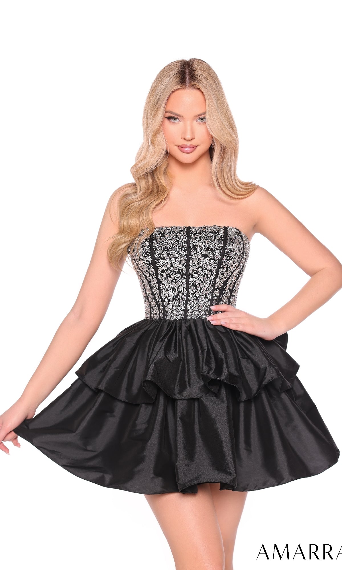 A woman wearing the Amarra 88952 Strapless Short Tiered Hoco Dress with a beaded corset-style bodice and layered skirt stands against a white background.